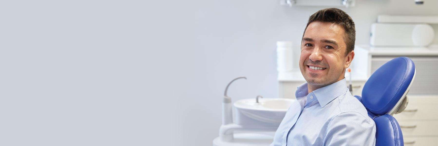 Confident man smiling in dental chair illustrating success of Dental Phobia Solutions