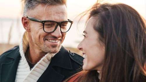 Couple smiling at each other, enjoying their bright, white smiles after a teeth whitening treatment